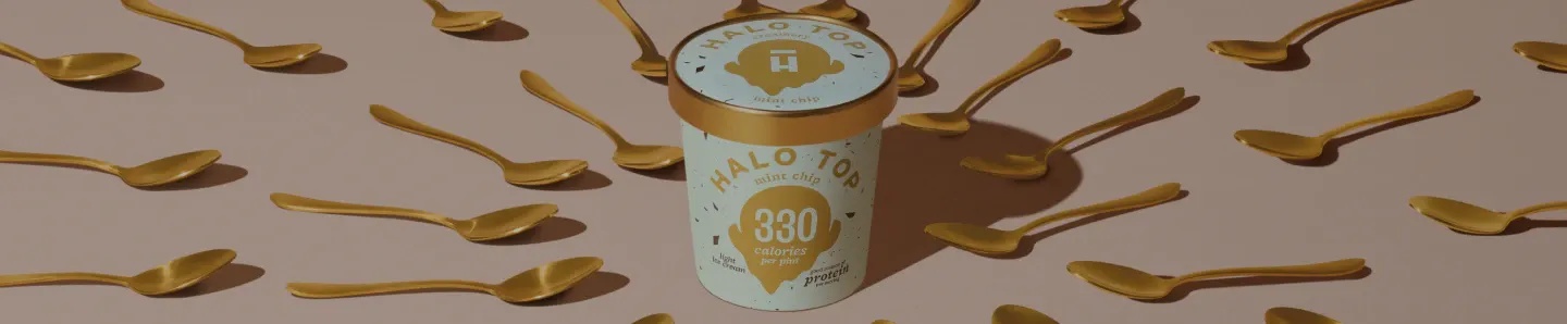 Hero BG Image - Desktop.webp Halo Top Pint surrounded by golden spoons.