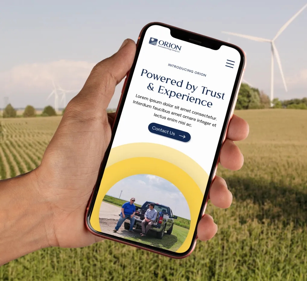 Hand holding mobile phone displaying Orion's website homepage.