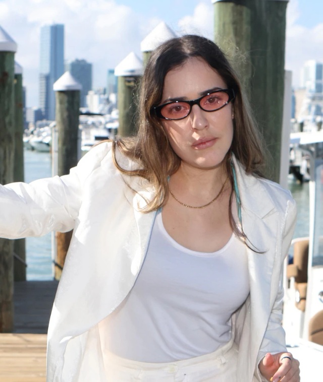 Outdoor photography by the pier Woman wearing dark glasses posing next to a dock and boats