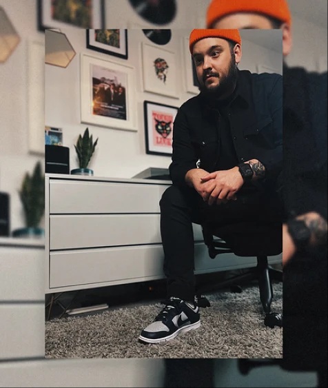 Man weairng black clothes and orange hat. Image of a man wearing black clothes and a orange hat.