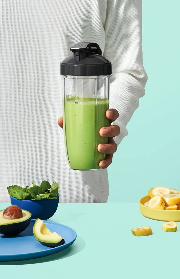 nb-work-mobile.webp Image of a man holding a nutribullet with green smoothie on a mint background.